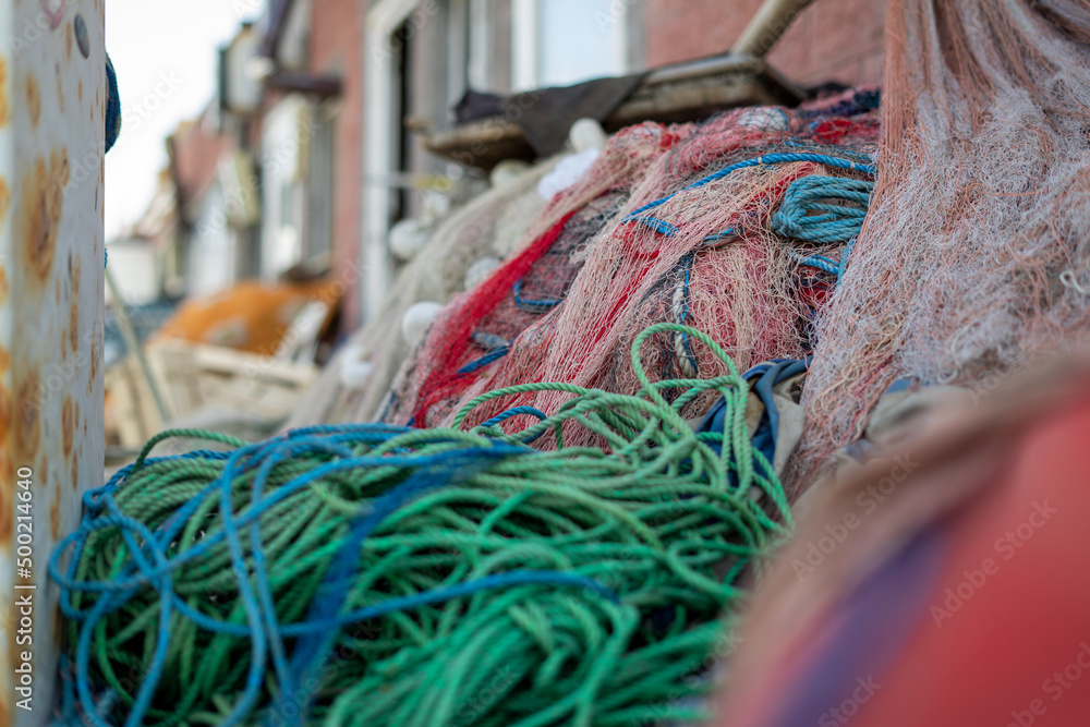 Stacked fishing nets and ropes red, green, blue and white