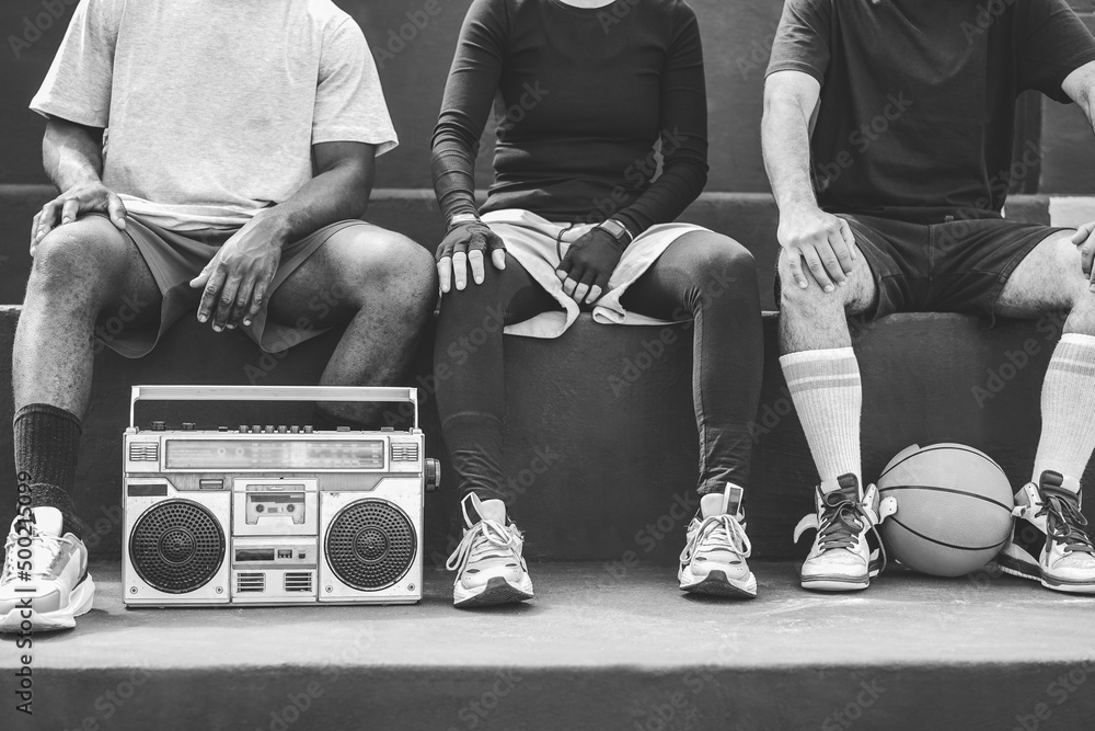 Group of young african people listening music outdoor after basketball match - Focus on boombox stereo - Black and white editing - obrazy, fototapety, plakaty 