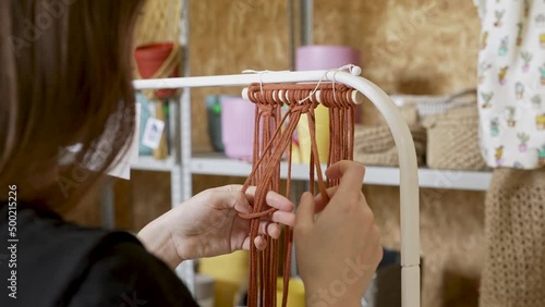 Close up of girls hands weaves handmade macrame at art school studio. Group of women attending art class. Female students and teacher makes home decor in Boho style in workshop together