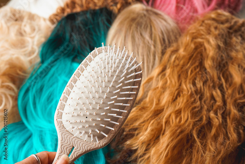 Wallpaper Mural Close up of a hair brush against a background of a lot of wigs Torontodigital.ca