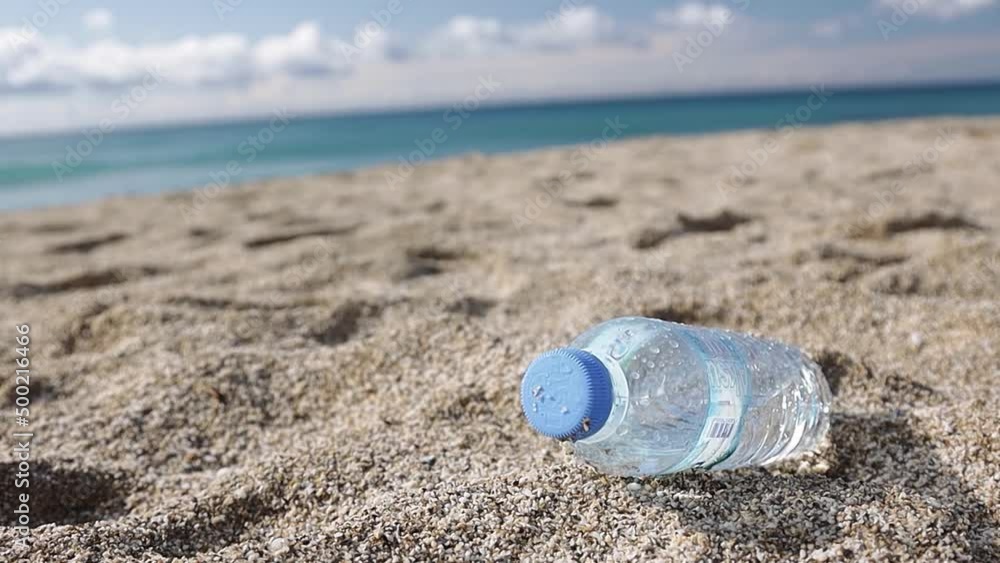Garbage pollution of the planet. Empty plastic bottle on the beach sand. Consequences of human life Garbage pollution of the planet. Empty plastic bottle on the beach sand. Consequences of human life