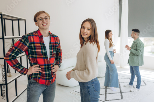 Young attractive group of friends talking and laughing with the happy during the meeting, standing at home, having fun and enjoying the game in their free time together.