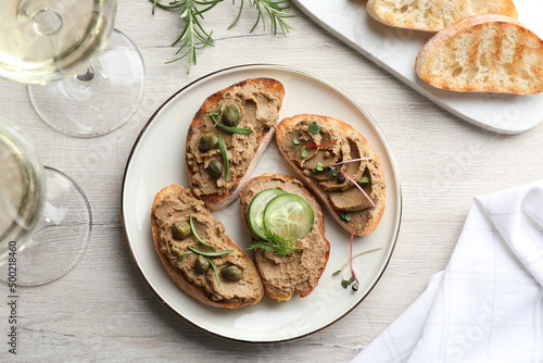 Slices of bread with delicious pate served on white wooden table, flat lay