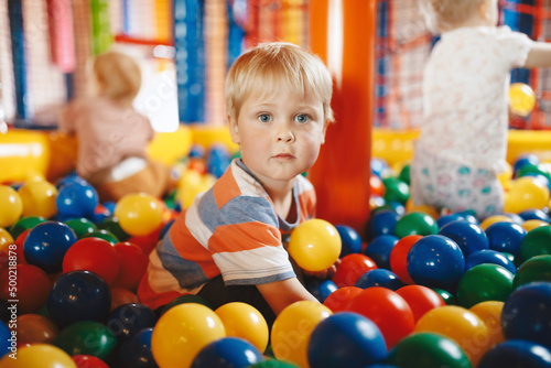 Kids Having Fun in Playground Ball Pool at Amusement Centre. Entertainment Centre for Elementary Age Kids. School Boy Playing in Pool Filled With Plastic Balls. Happy Children Playing in Ball Pool.