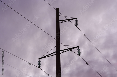 Electric pole and electric cables at sunset. Silhouette.