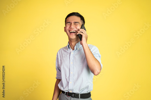 young businessman laughing while making phone call on isolated background