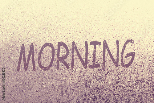Word morning written on foggy window, closeup view