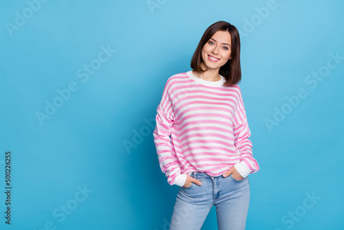 Photo of sweet charming woman wear striped sweater arms pockets empty space isolated blue color background