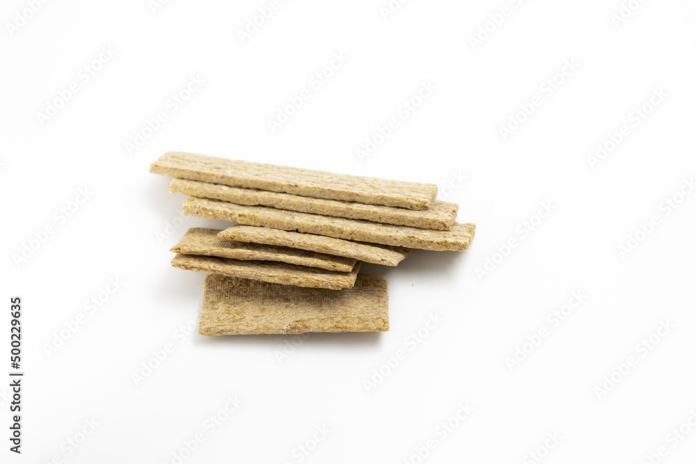 A pile of dry wheat light slices of dry diet bread on a white background isolated top view