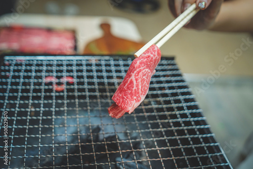 Close up of Piece of raw sliced beef on charcoal grill at Outdoor party. Home made barbecue beef grill smoke.