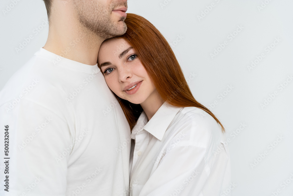 Smiling redhead woman looking at camera near boyfriend isolated on white. Smiling redhead woman looking at camera near boyfriend isolated on white.