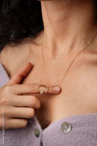 Close-up young woman wearing gold chain necklace. Modern fashion details. minimalist lifestyle