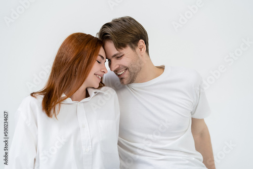 Happy young couple smiling with closed eyes isolated on white.