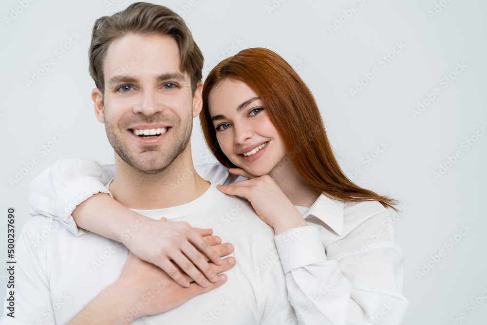 Smiling red haired woman hugging boyfriend isolated on white. Smiling red haired woman hugging boyfriend isolated on white.