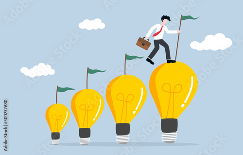 Self creativity growth along career path, mindset development, growing idea through facing higher level work concept. Creative businessman step and flag on top of ascending size light bulb ideas.