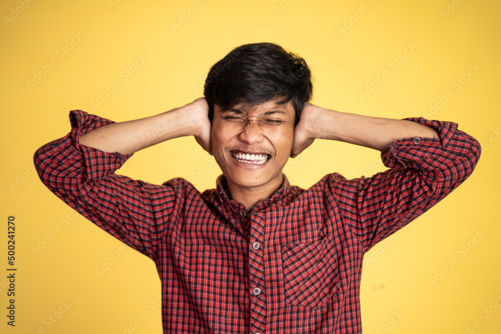 Stressed asian young young man holding head on isolated background Stressed asian young young man holding head on isolated background