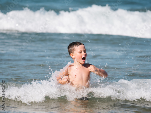 happy child seen from the front having fun with the waves of the sea © 23_stockphotography