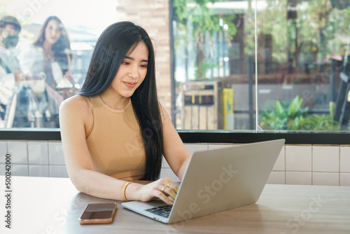 attractive young business woman using laptop computer at coffee shop in the urban