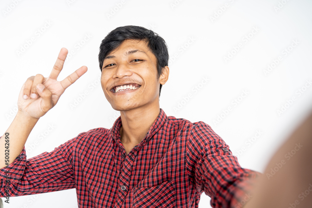 happy asian man taking selfie with phone camera on isolated background happy asian man taking selfie with phone camera on isolated background