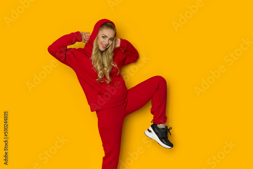 Cheerful woman posing in sweatpants and hooded sweatshirt photo