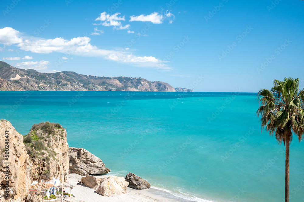Travel destination, view on sandy beach, blue sea and mountains from Balcon de Europa in small Andalusian town Nerja with white houses and narrow streets on Costa del Sol, Spain Travel destination, view on sandy beach, blue sea and mountains from Balcon de Europa in small Andalusian town Nerja with white houses and narrow streets on Costa del Sol, Spain