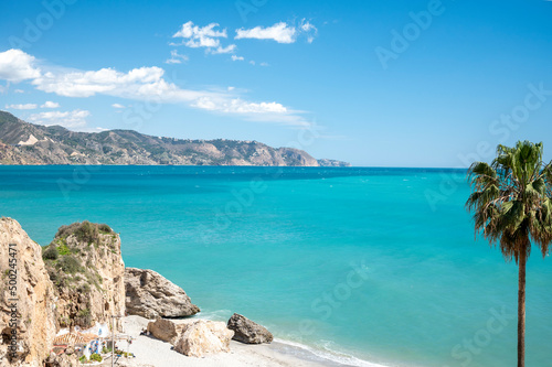 Fototapeta Naklejka Na Ścianę i Meble -  Travel destination, view on sandy beach, blue sea and mountains from Balcon de Europa in small Andalusian town Nerja with white houses and narrow streets on Costa del Sol, Spain
