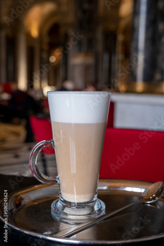 Glass cup of coffee latte served in classic old Austrian café-restaurant in Vienna