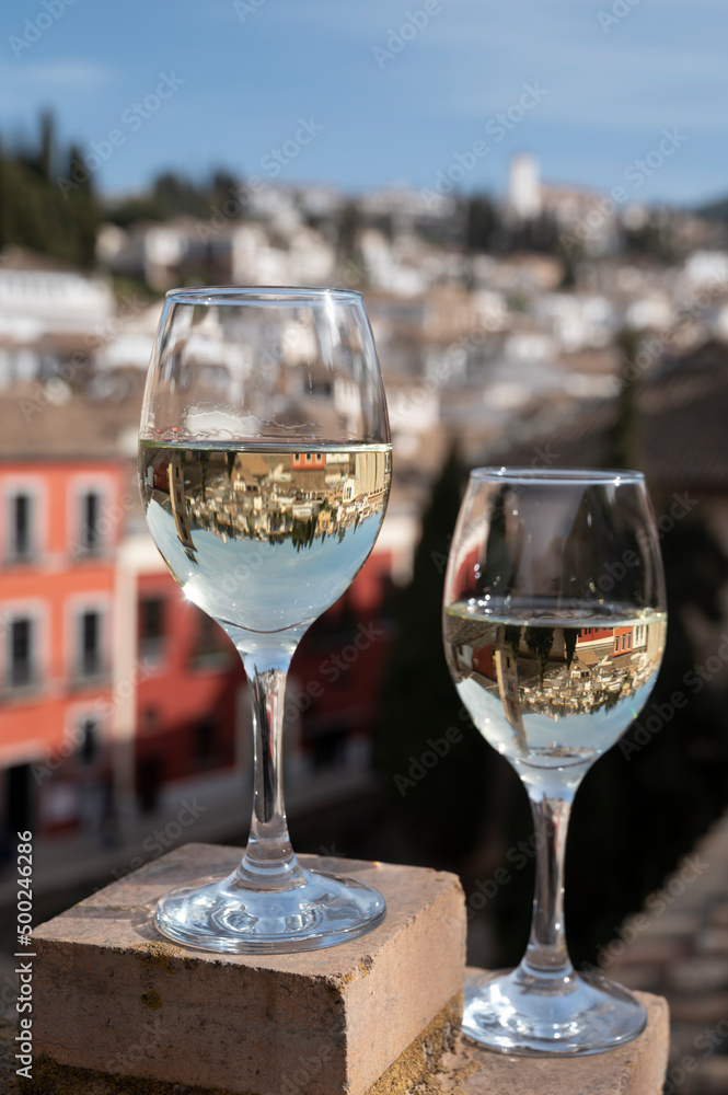 Two glasses of Spanish dry rueda white wine served on roof terrace with view on old part of Andalusian town Granada, Spain Two glasses of Spanish dry rueda white wine served on roof terrace with view on old part of Andalusian town Granada, Spain
