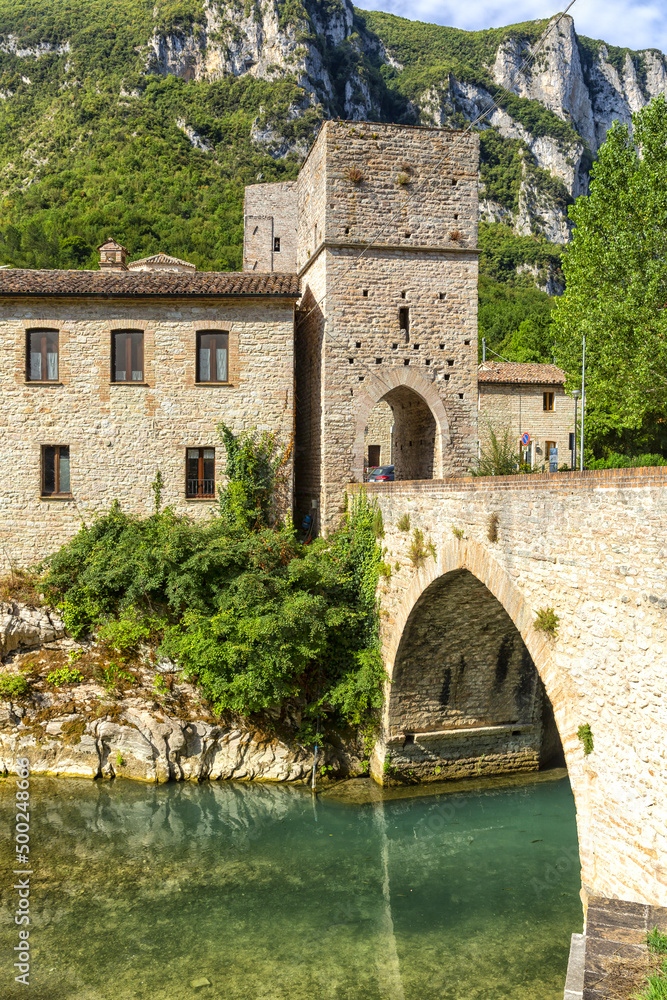San Vittore alle Chiuse. Roman Catholic abbey and church. The edifice is known from the year 1011. Ponte Romano. Roman bridge over a small river. Italy.