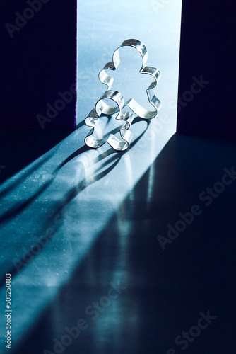 Fototapeta Naklejka Na Ścianę i Meble -  Cookie cutters with shadow lighting. Symbolic images of a person on the border of light and darkness.