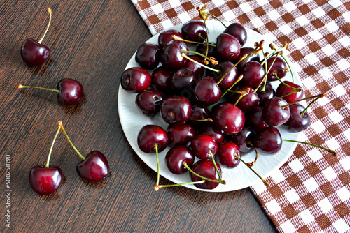 heap of dark red cherries on kitchen table, close-up