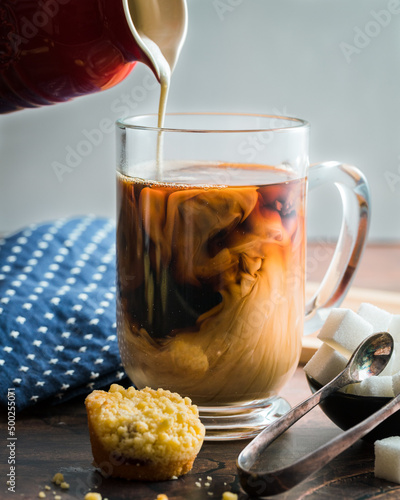 Coffee with creamer being poured into the cup