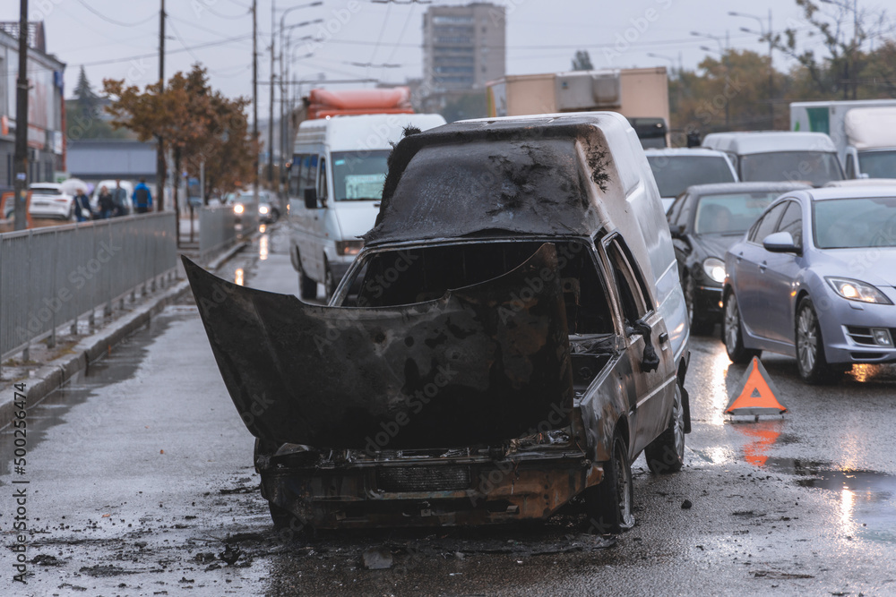 The car caught fire while driving on a road in the city. Traffic jam on the road. Severe vehicle damage. The car caught fire while driving on a road in the city. Traffic jam on the road. Severe vehicle damage.