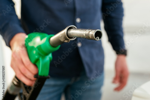 Anonymous man refilling vehicle tank at petrol station photo