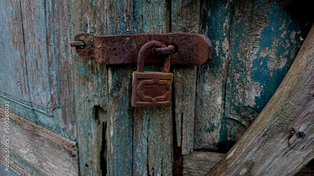 Rusty padlock with broken wooden door
Rusty padlock with broken wooden door