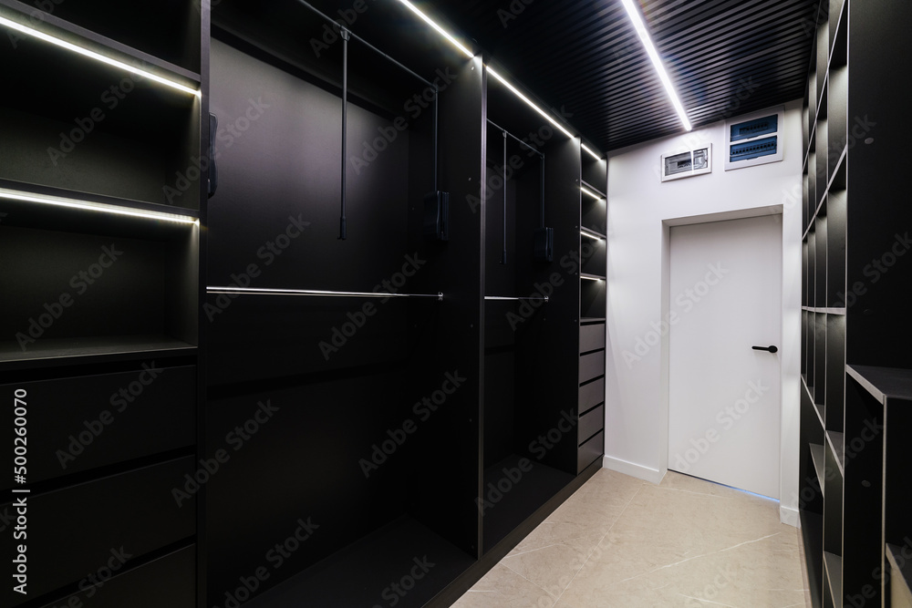 Bright lighting in a black wardrobe in the interior of the house
