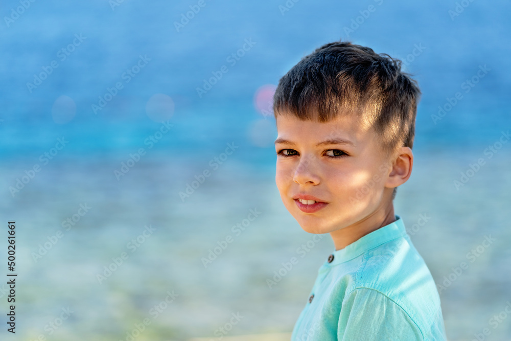 Portrait of a cute caucasian young boy with azure sea on the background. Summer holidays and happy childhood concept. Portrait of a cute caucasian young boy with azure sea on the background. Summer holidays and happy childhood concept.
