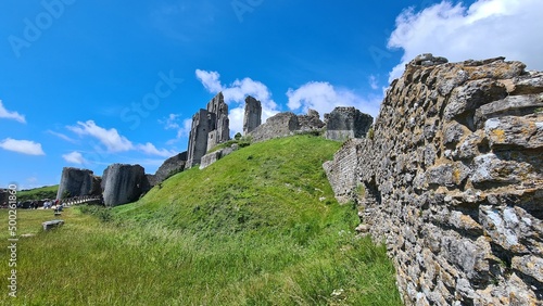 Corfe Castle with blue sky and wall