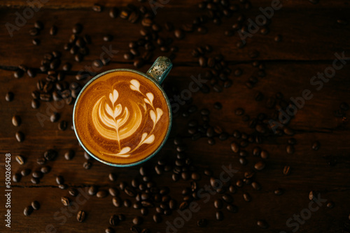 Coffee latte in cup on wooden table background.