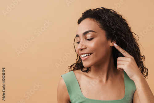 Print op canvas Young black woman smiling and pointing finger at her ear