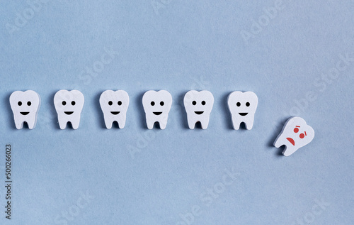 Tooth loss. Teeth row with fallen baby milk or adult one on blue background. Cavity, poor oral hygiene, gums inflammation, trauma. High quality photo