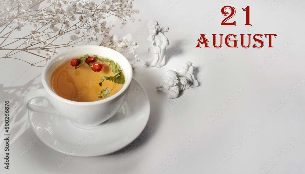 calendar date on light background with a porcelain cup of green tea, white gypsophila and angels with copy space. August 21 is the twenty first day of the month calendar date on light background with a porcelain cup of green tea, white gypsophila and angels with copy space. August 21 is the twenty first day of the month