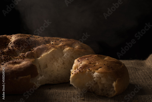 Close up shot of a hand divided Ramadan pita bread on a jute background. photo