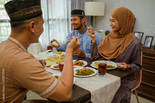 asian muslim young people having iftar dinner together at home