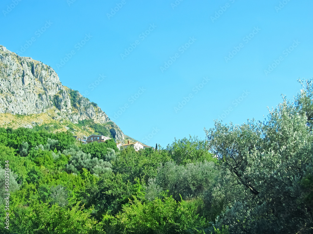 A wall of mountains rises above the valley. Warm tones on a sunny day with a small village in the hills. Mountains rock granite A wall of mountains rises above the valley. Warm tones on a sunny day with a small village in the hills. Mountains rock granite