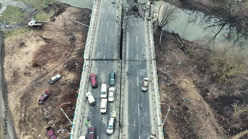Destroyed bridge in Irpen city. Bombed city in Ukraine. Blown up cars.