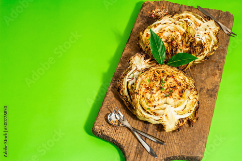 Homemade vegan cabbage steaks with herbs and spices. Healthy food ready to eat on a cutting board