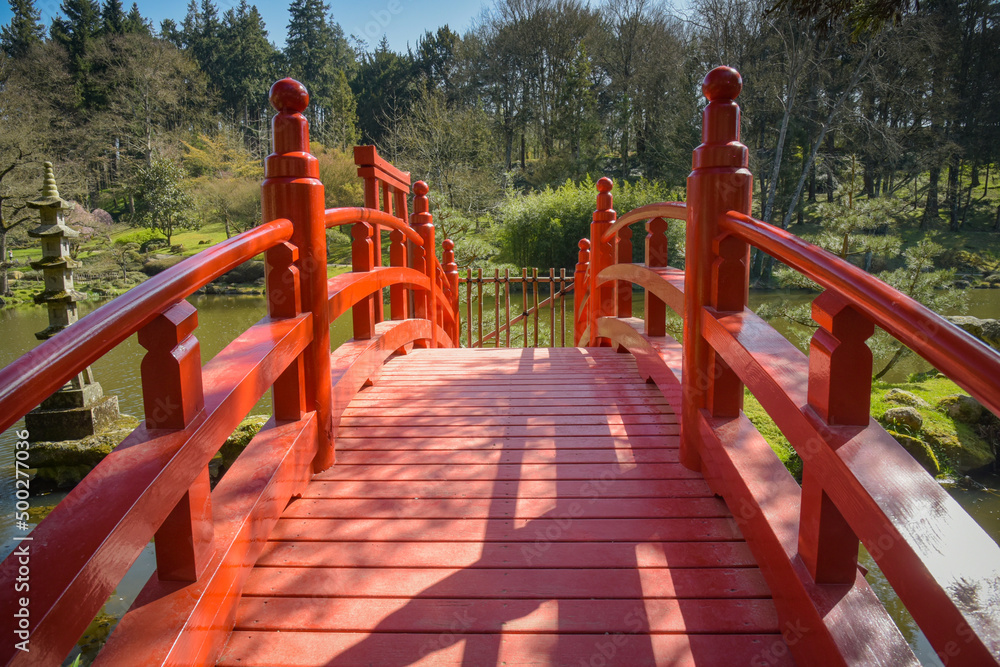 view on a beautiful red bridge in a park view on a beautiful red bridge in a park