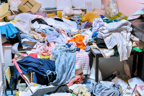 A room cluttered with piles of clothes
