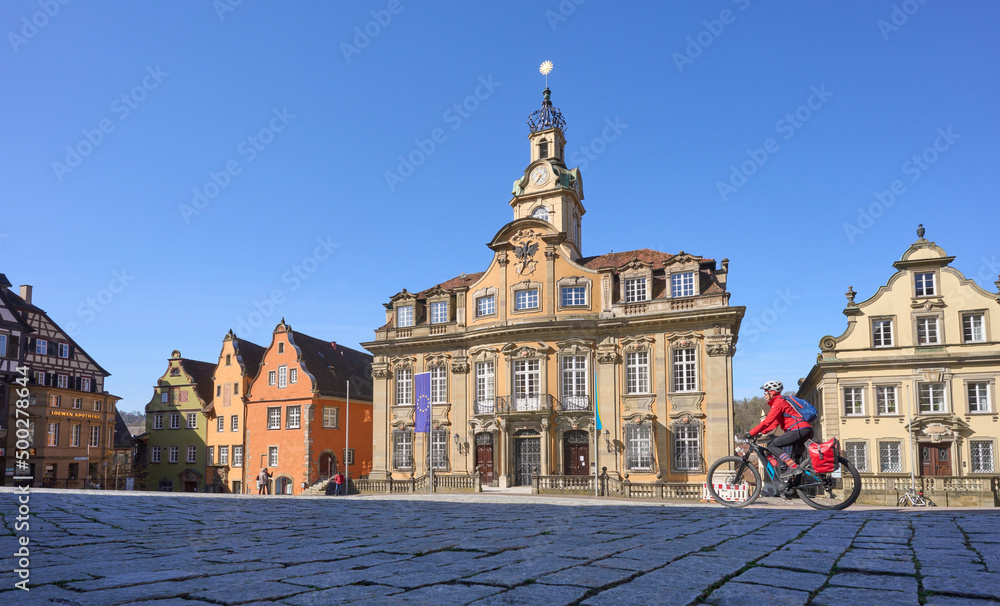 woman on bicycle tour in downtown of Schwaebisch Hall, one of the most famous  medieval cities in Germany 